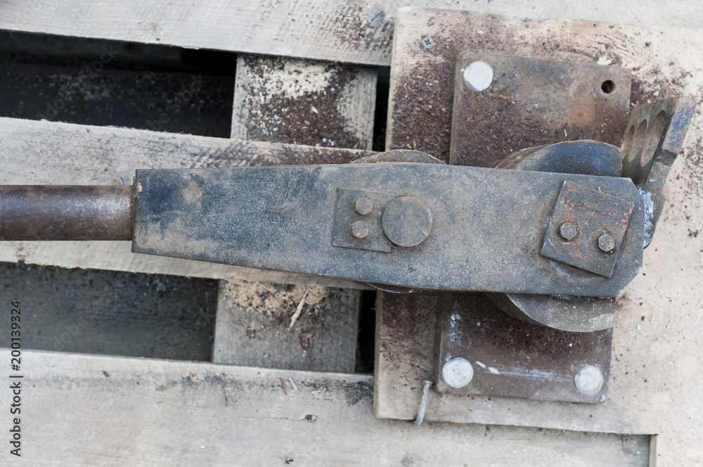 Old hand tool for bending pipe is fixed on a tree Old hand tool for bending pipe is fixed on a tree