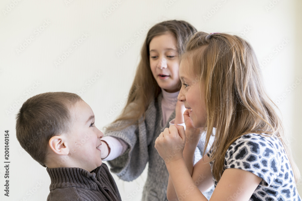 Two little girls beat the boy. Light background. European appearance. Two little girls beat the boy. Light background. European appearance.