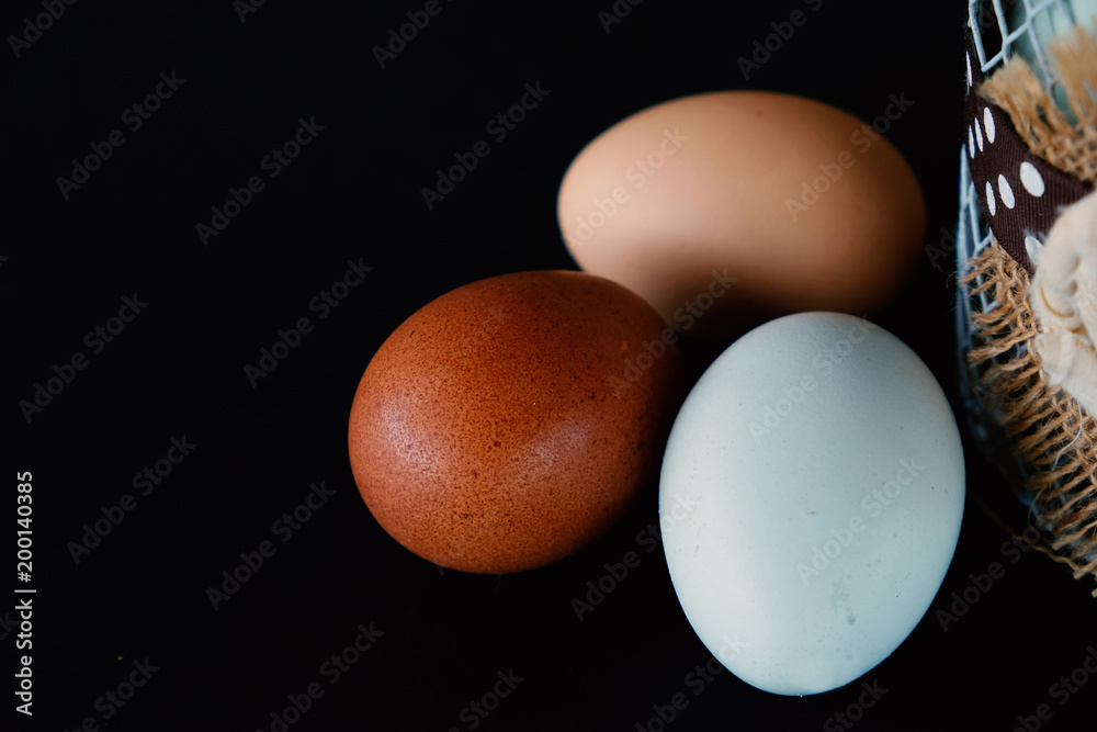 Three cage free chicken eggs isolated on black background. Breakfast food from agriculture. Three cage free chicken eggs isolated on black background. Breakfast food from agriculture.