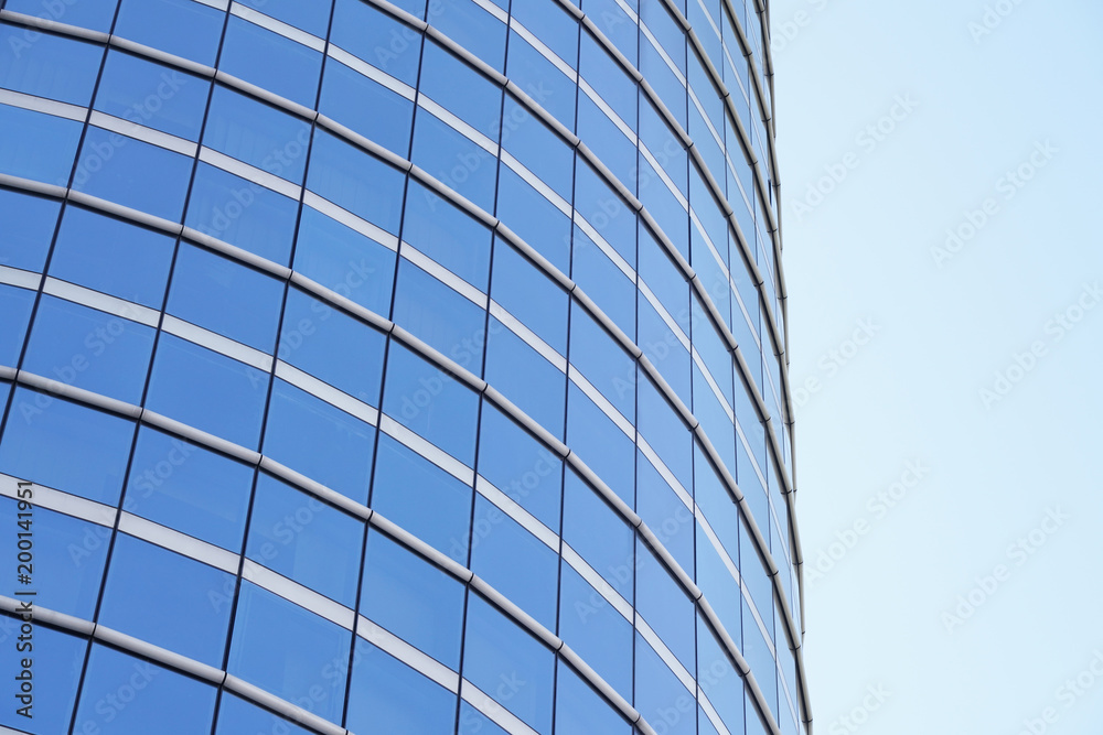low angle view of modern curved blue glass building low angle view of modern curved blue glass building