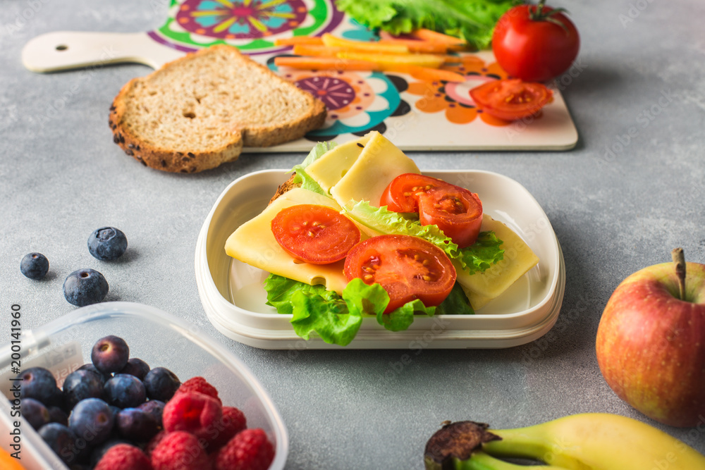 Mother giving healthy lunch for school in the morning Mother giving healthy lunch for school in the morning