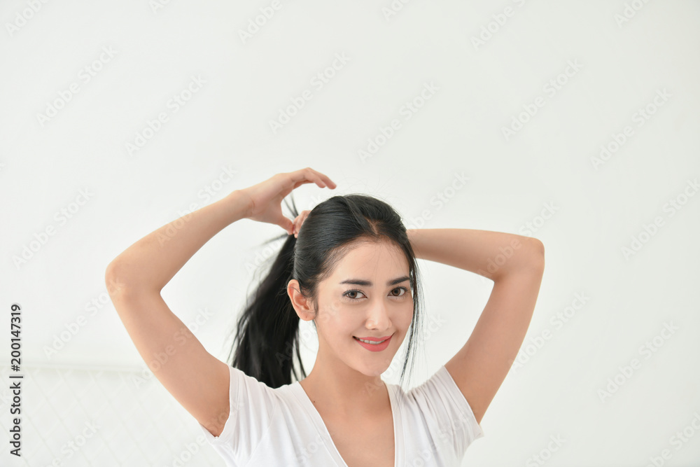 Lifestyle Concept. Cute Asian girl in night dress. Beautiful asian woman is relaxing in a white bedroom. Asian girls are playing in the bedroom happily. Lifestyle Concept. Cute Asian girl in night dress. Beautiful asian woman is relaxing in a white bedroom. Asian girls are playing in the bedroom happily.