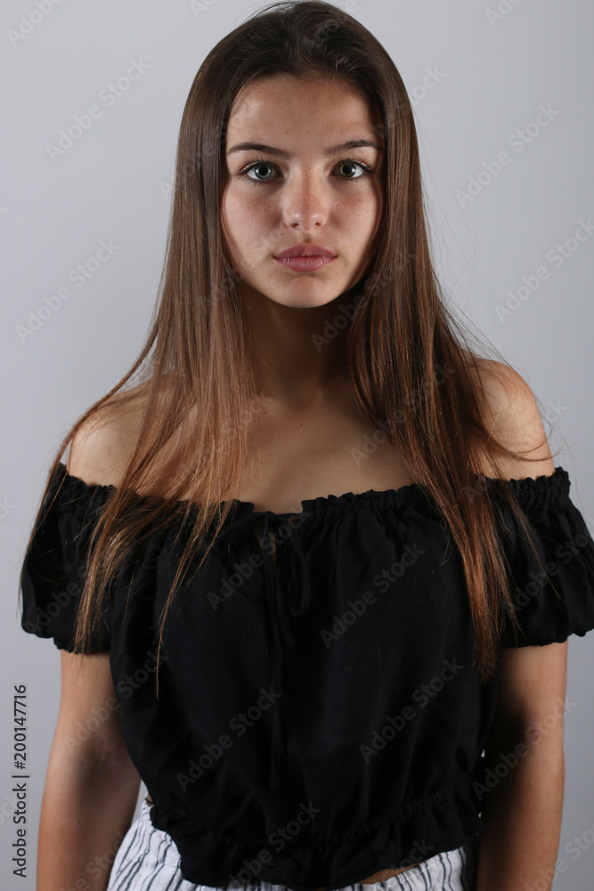 Belle adolescente posant devant un fond gris Belle adolescente posant devant un fond gris