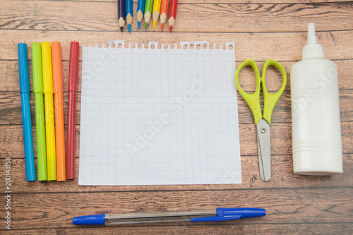 School supplies. Color pencils,note book, blue pens, sciccors, markers, glue, pencil sharpener, clips photo