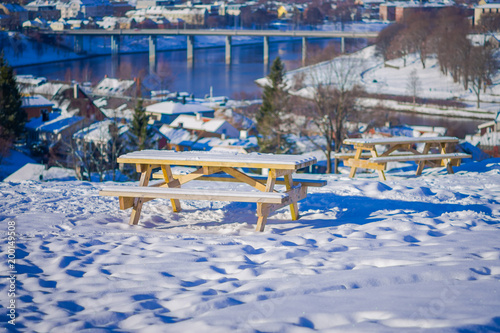 Beautiful outdoor view of wooden chair and the norwegian city Trondheim in the horizont in the winter