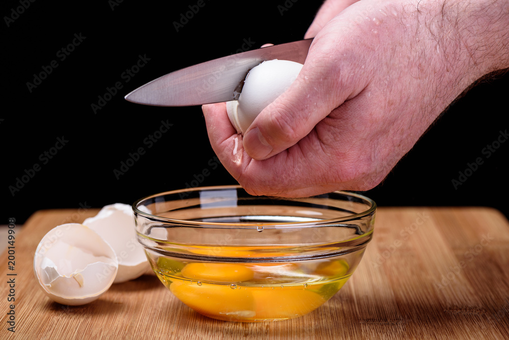 Opening eggshell, protein flowing on the finger Opening eggshell, protein flowing on the finger