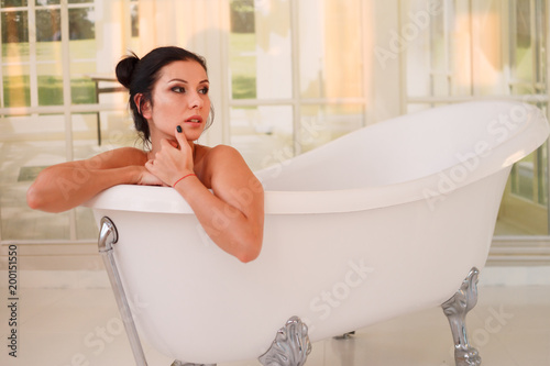 Beautiful young sexy girl with dark hair in bathtub