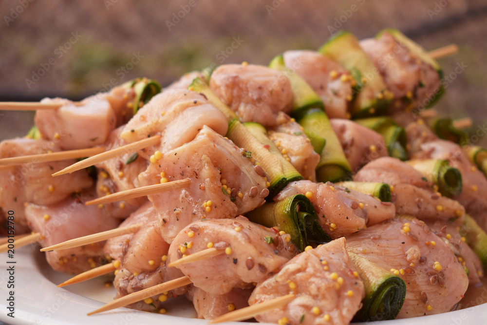 Raw Marinated Chicken Meat Skewers. Barbeque Summer Picnic Food. Grilled Meat over Wooden Background with Spices Raw Marinated Chicken Meat Skewers. Barbeque Summer Picnic Food. Grilled Meat over Wooden Background with Spices
