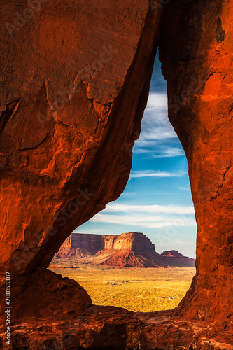 The Eagle Mesa seen through the Teardrop Arch in Monument Valley Navajo Tribal Park at sunset with beautiful and vibrant colors, Utah. photo