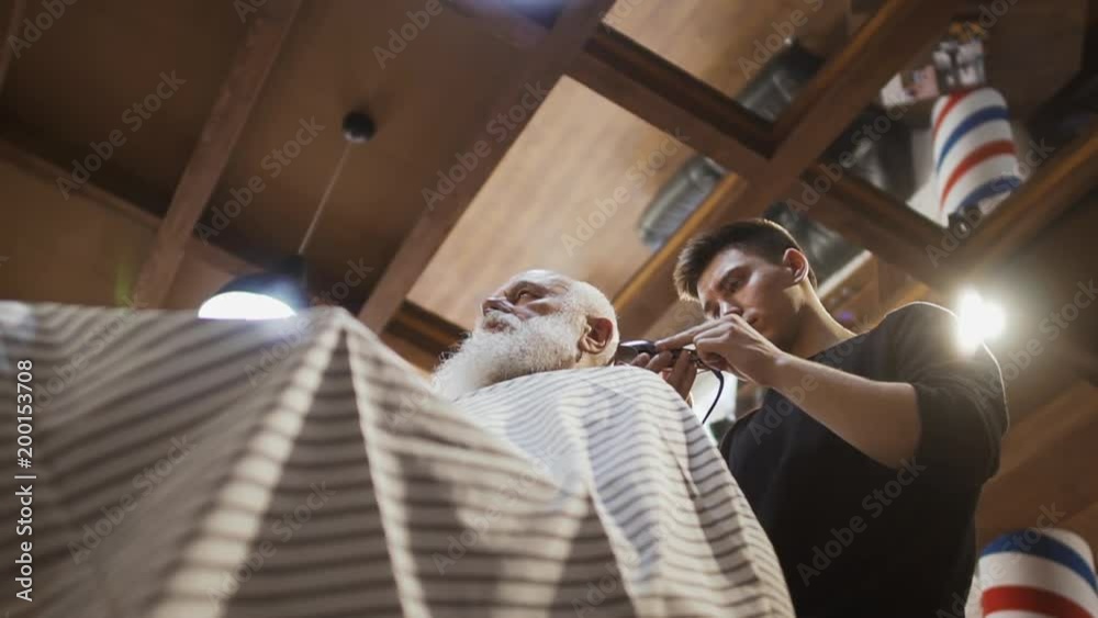 Hairdresser makes stylish haircut for senior man Hairdresser makes stylish haircut for senior man