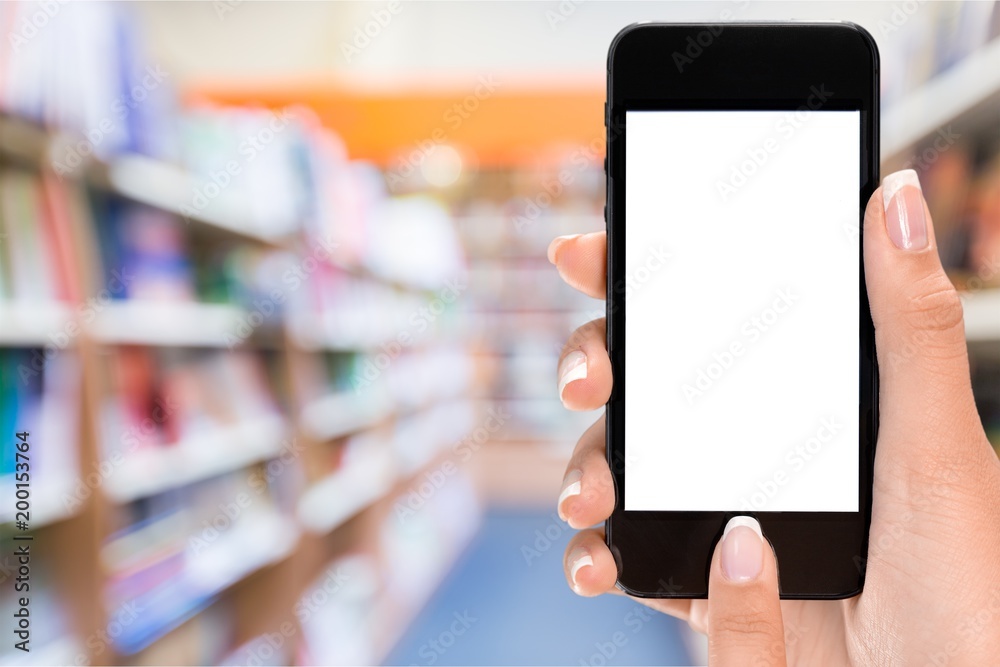 Hand holding phone on blurred background Hand holding phone on blurred background