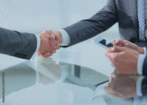 Two confident businessmen shaking hands during a meeting in the © ASDF