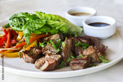 Grilled sliced beef steak with lettuce and chopped pepper - Stok Photo