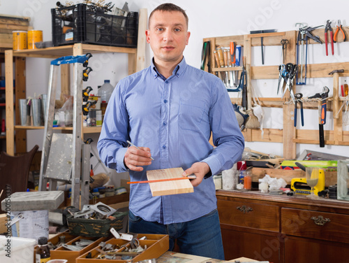 Adult man working with wood at workplace
