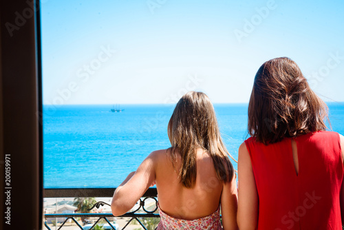 Mother and daughter looking on the sea