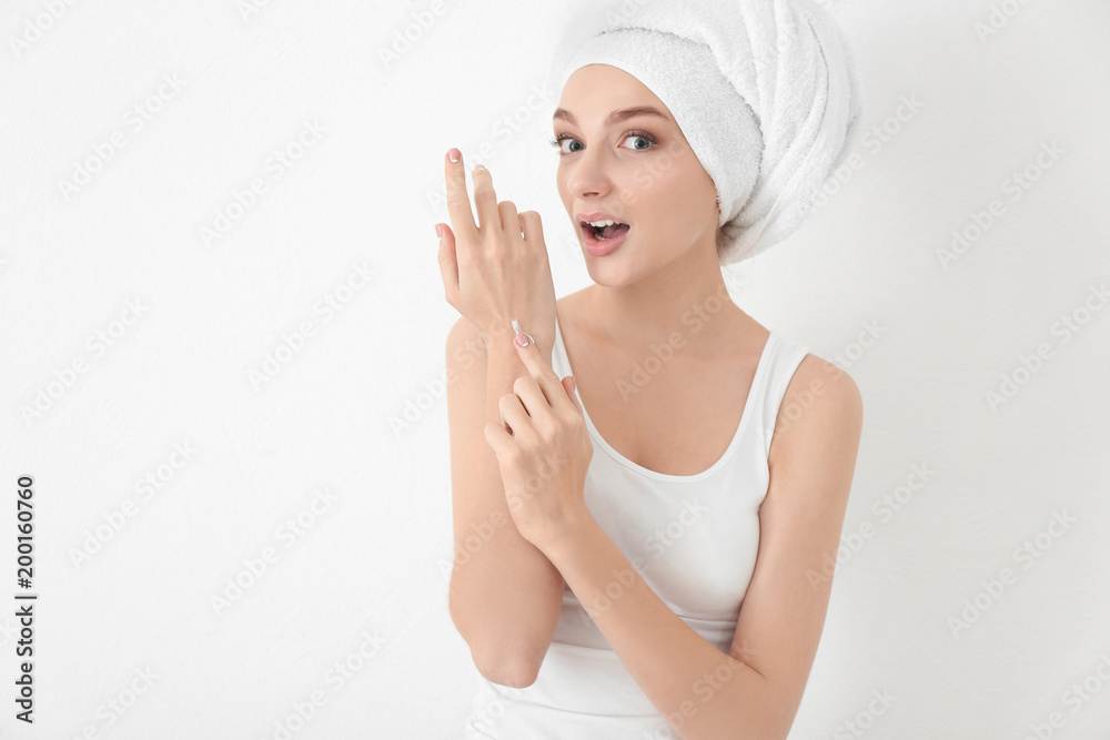 Young woman applying hand cream, on white background Young woman applying hand cream, on white background