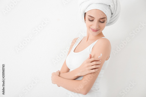 Wallpaper Mural Young woman applying body cream, on white background Torontodigital.ca
