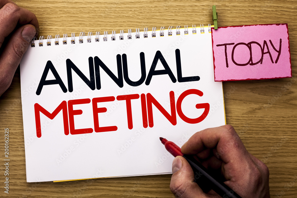 Word writing text Annual Meeting. Business concept for Yearly Company Assembly Business Conference Report Event written by Man on Notebook Book Holding Marker on the Wooden background Today.