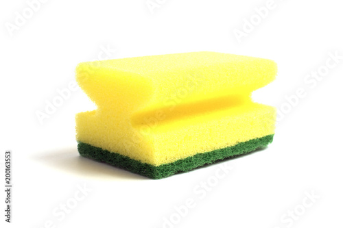 Photo of a dish sponge that consists of yellow foam and green abrasive on a white background