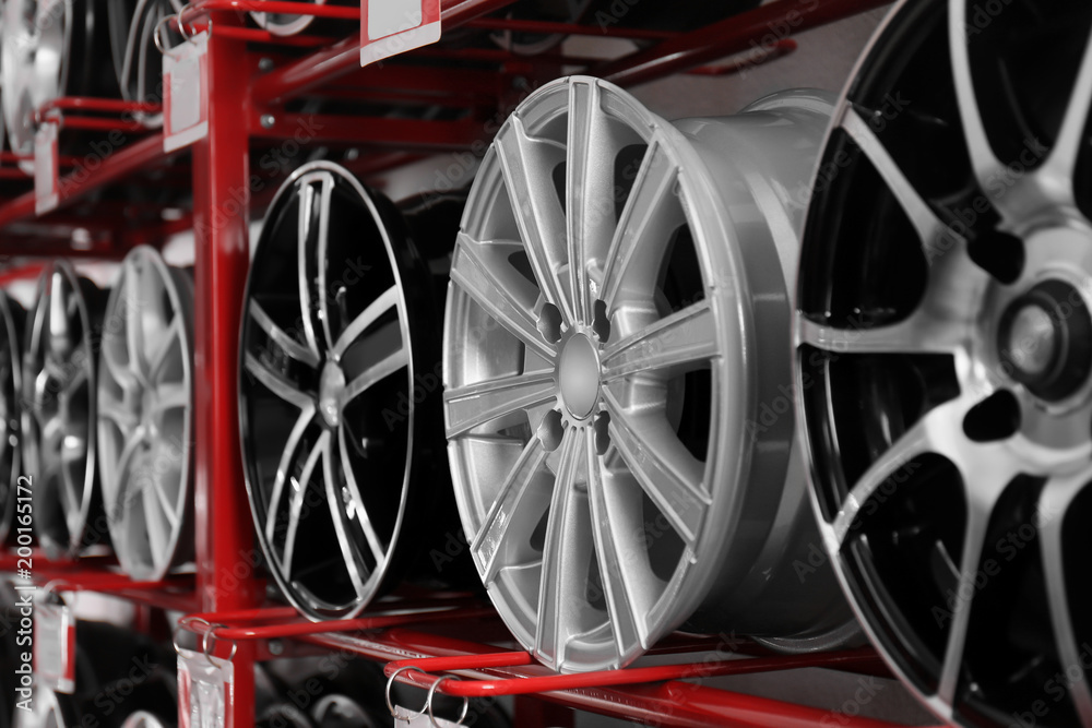 Stand with alloy wheels in modern tire store