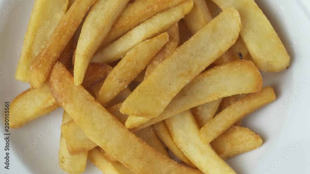 Top view closeup of delicious french fries in white plate - spinning shot Top view closeup of delicious french fries in white plate - spinning shot