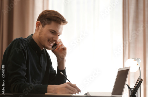 Young man talking on phone ...