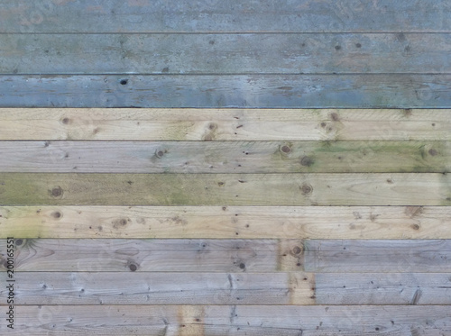 colorful old rustic wooden plank wall or floor with some of the boards stained blue made of reused timber