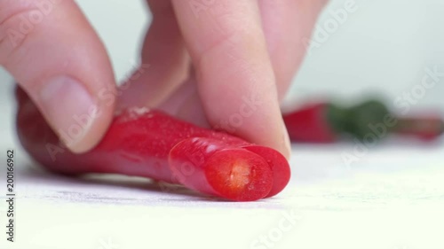 Red peppers on cutting board and knife on white background. photo