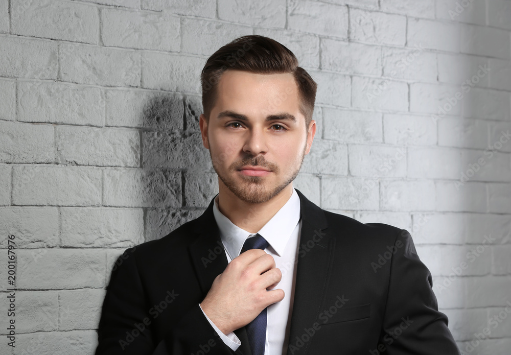 Portrait of young man with beautiful hair on brick wall background Portrait of young man with beautiful hair on brick wall background