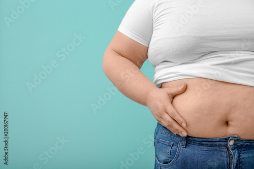 Overweight woman on color background