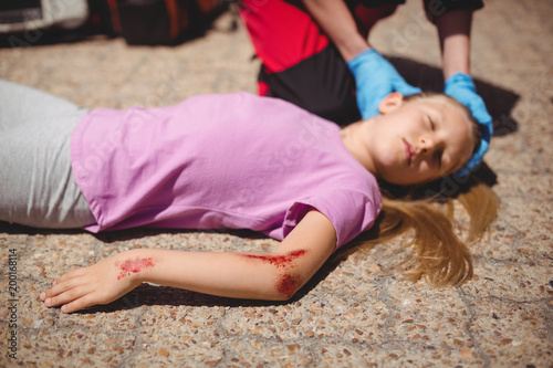 Unconscious girl fallen on ground after accident photo