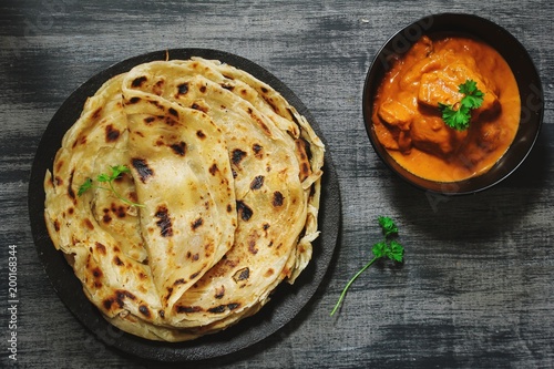 Homemade Kerala wheat paratha or layered  parotta  served with Paneer curry, top view