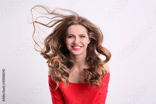 Portrait of young woman with long beautiful hair on white background