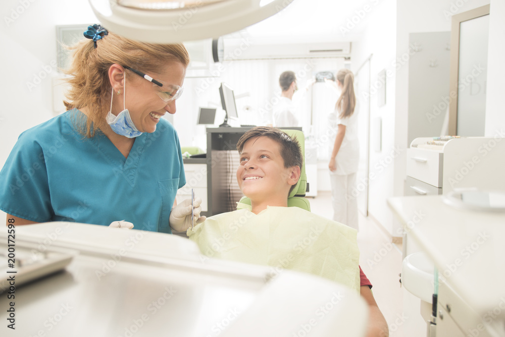 Boy with perfect teeth at the dentist doing check up with the clinic at the background - oral hygiene health care concept Boy with perfect teeth at the dentist doing check up with the clinic at the background - oral hygiene health care concept