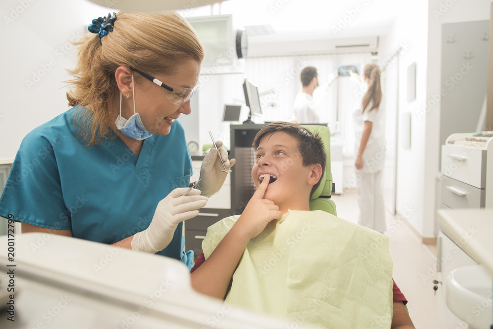 Boy with perfect teeth at the dentist doing check up with the clinic at the background - oral hygiene health care concept Boy with perfect teeth at the dentist doing check up with the clinic at the background - oral hygiene health care concept