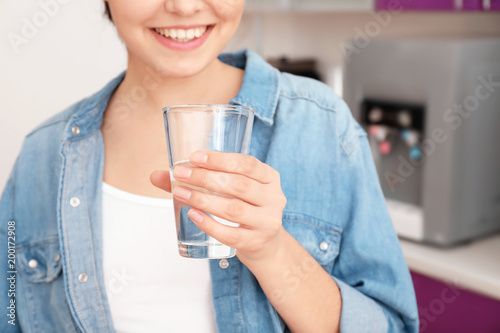Woman with glass of water from cooler in office