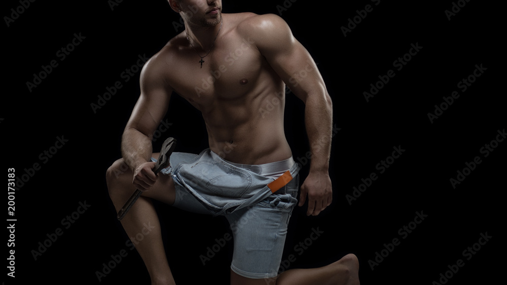 Obraz premium Sexy Worker concept. Young muscular shirtless man in denim uniform