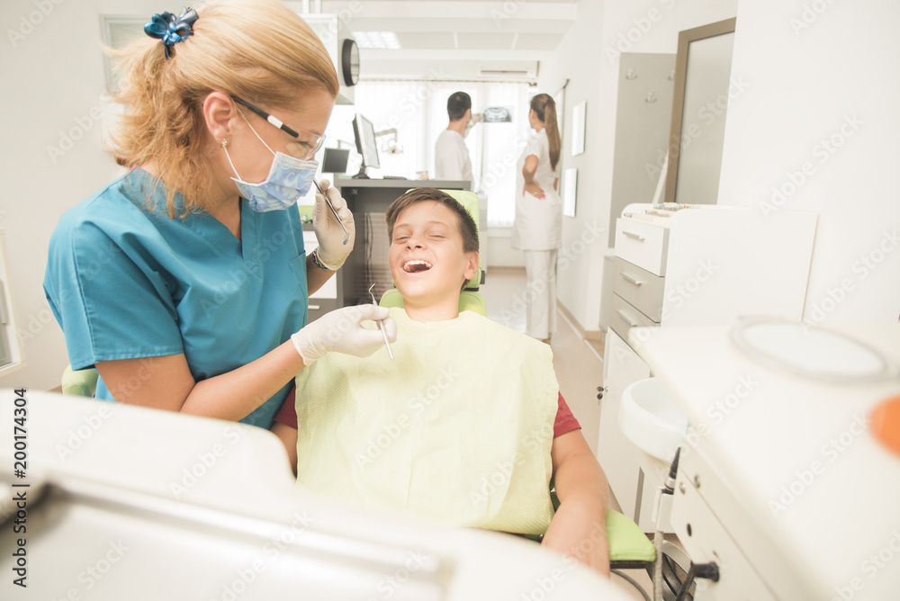 Young teenager is terrified at the dentist with the clinic at the background - oral hygiene health care concept Young teenager is terrified at the dentist with the clinic at the background - oral hygiene health care concept