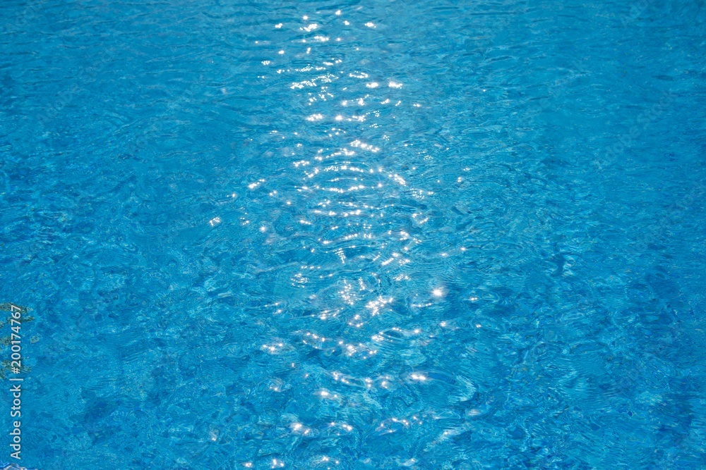 water ripples texture in swimming pool with sunny glare