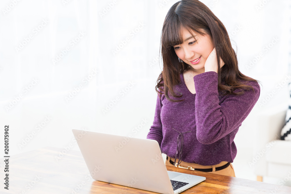 部屋でラップトップコンピューターを見る女性 部屋でラップトップコンピューターを見る女性