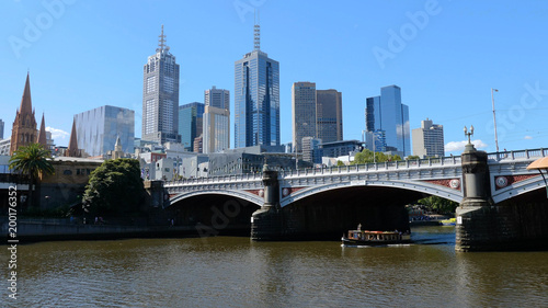 Melbourne, Australia. Skyscrapers and the bridge over the Yarra river. Boat passes through the Princes Bridge