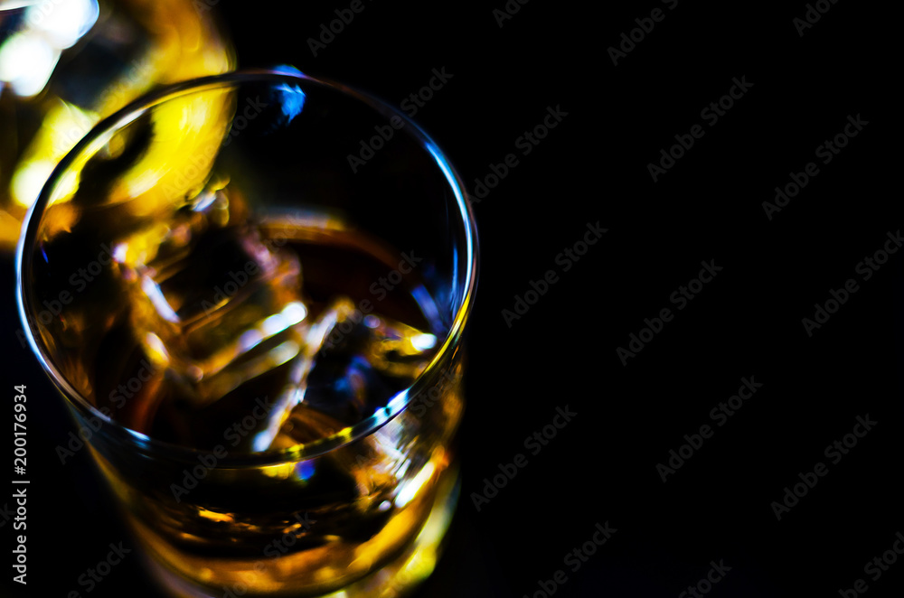 Scottish whiskey in a glass with ice cubes, golden color whiskey Scottish whiskey in a glass with ice cubes, golden color whiskey