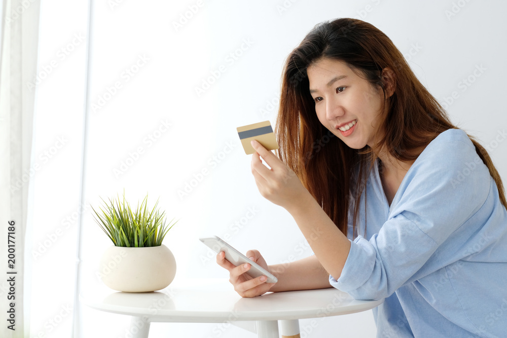 Young asian woman holding credit card and using smart phone for shopping online, business and technology concept, online payment, digital money Young asian woman holding credit card and using smart phone for shopping online, business and technology concept, online payment, digital money