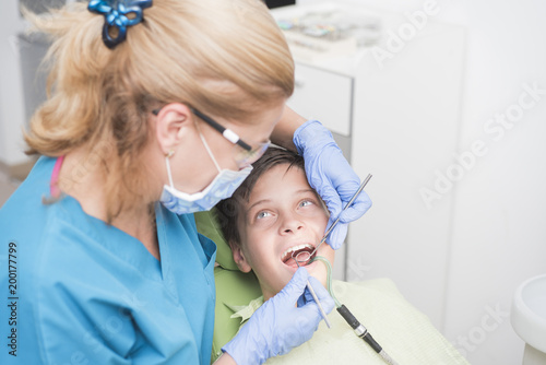 Boy polishing his teeth at the dentist - oral hygiene health care concept