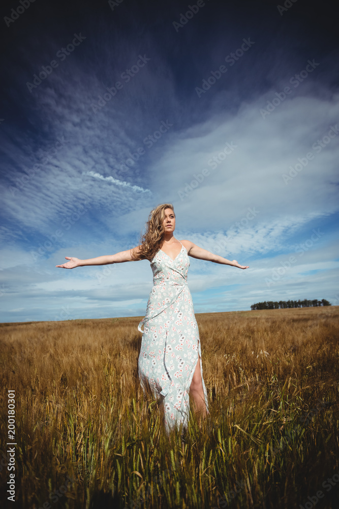 Woman standing with arms outstretched in wheat field Woman standing with arms outstretched in wheat field