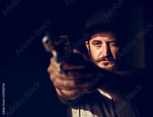 Man holding a gun wth black background