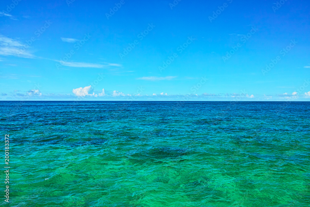 真夏の宮古島、来間島のプライベートビーチの前に広がるエメラルドグリーンの海

