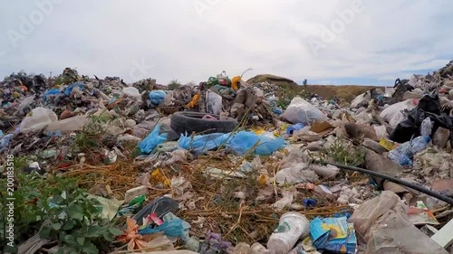 The camera moves through scattered garbage. Slow motion.