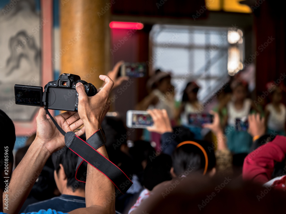 parent try to take video of their kid in acting day at school, by smartphone or digital camera parent try to take video of their kid in acting day at school, by smartphone or digital camera