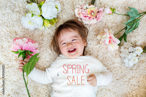 Spring Sale message with happy toddler boy with spring flowers